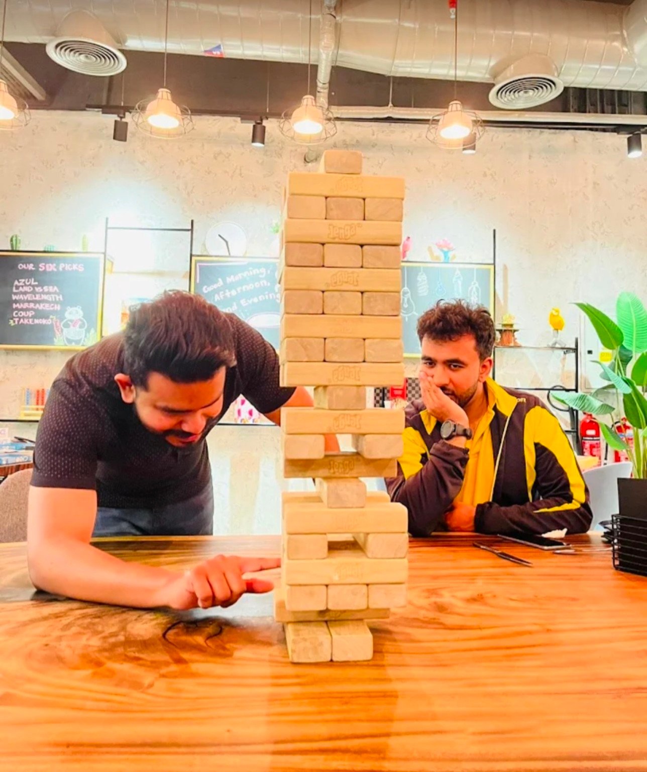Two guests concentrating on a giant Jenga game