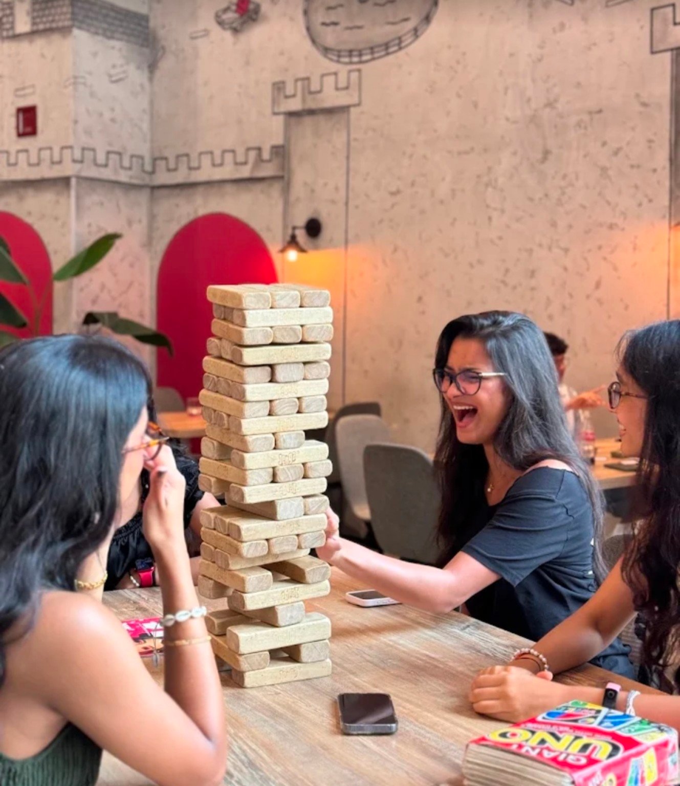 Friends laughing while playing Jenga